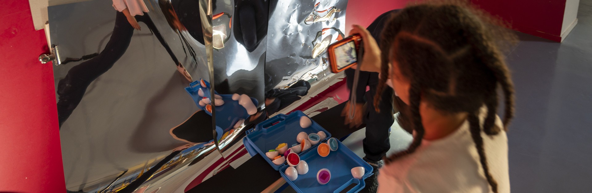 Un enfant se prend en photo dans un miroir déformant